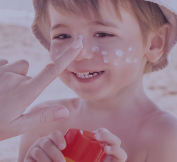 Junge mit Sonnencreme im Gesicht am Strand